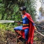 Un adolescent en Superman combat les incendies à Bornéo, mettant en lumière la crise écologique en Indonésie