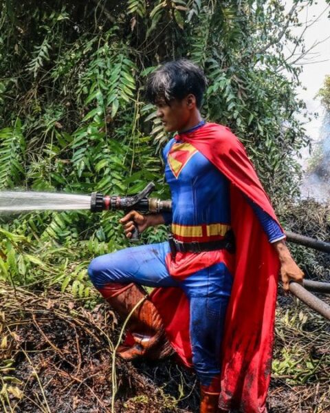 Un adolescent en Superman combat les incendies à Bornéo, mettant en lumière la crise écologique en Indonésie