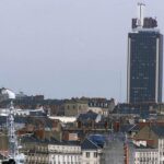 Un homme grimpe la Tour Bretagne à Nantes pour y accrocher des drapeaux chinois et américain