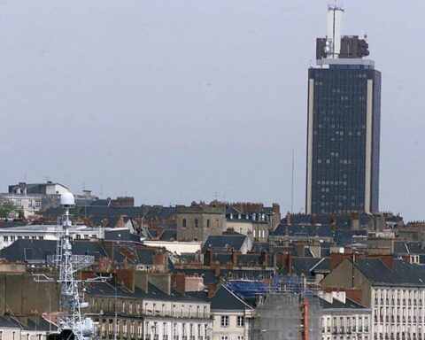 Un homme grimpe la Tour Bretagne à Nantes pour y accrocher des drapeaux chinois et américain