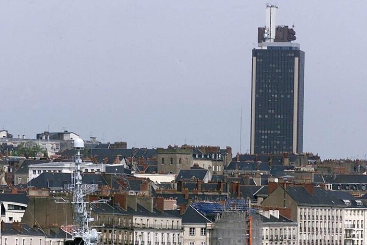 Un homme grimpe la Tour Bretagne à Nantes pour y accrocher des drapeaux chinois et américain